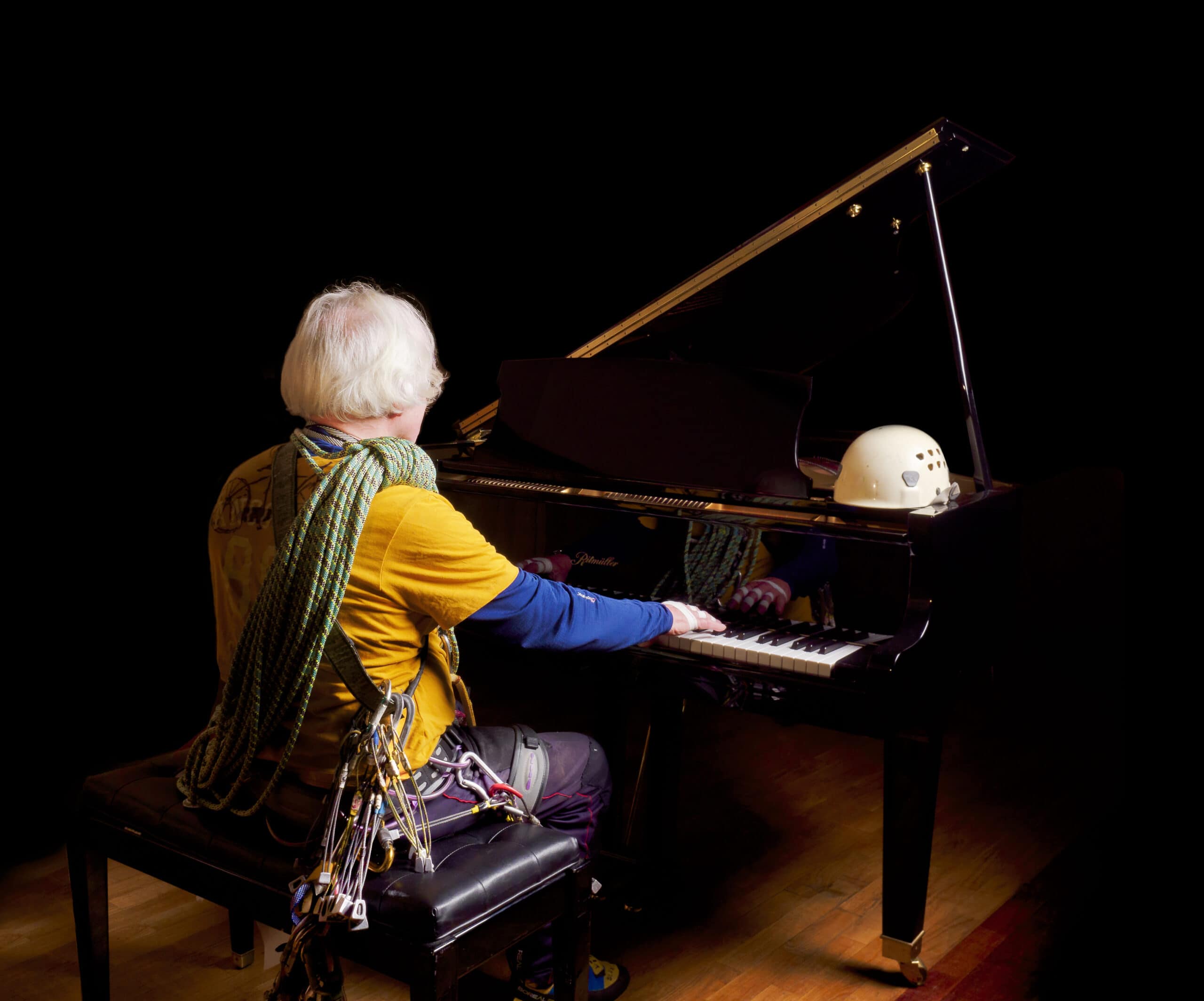 Euan Moseley at piano in climbing gear